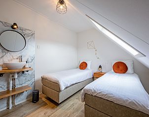 Tweepersoonskamer met wastafel in Windlust vakantiehuis De Koog Texel.