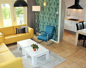 Gezellige woonkamer in 6p.Rietgedekte Vakantiehuis Eldorado Texel, De Koog, met kleurrijke meubels en moderne keuken, ideaal voor ontspanning.