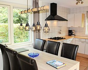 Moderne keuken in 6p.Rietgedekte Vakantiehuis Eldorado Texel, De Koog, met eethoek en uitzicht op de groene omgeving van de Waddeneilanden.