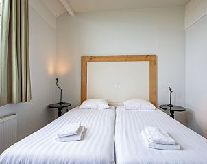 Comfortabele slaapkamer in Appartement - 4-persoons (0034), De Koog, Texel met tweepersoonsbed en uitzicht.