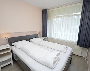 Schlafzimmer im Apartment Kerckeland 70, De Koog, Texel mit Doppelbett und groen Fenstern.