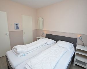 Gemtliches Schlafzimmer im Apartment Kerckeland 70, De Koog, Texel mit Nachttischen und Beleuchtung.