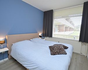 Comfortabele slaapkamer in Appartement Kerckeland 106, De Koog, Texel met tweepersoonsbed en uitzicht op buiten.