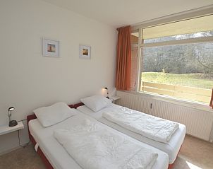 Comfortabele slaapkamer in Appartement Kerckeland 28, De Koog, Texel, met uitzicht op de groene omgeving.