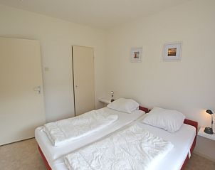 Ruime slaapkamer van Appartement Kerckeland 28, De Koog, Texel, met twee eenpersoonsbedden en serene sfeer.