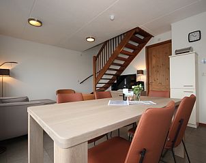 Cozy interior of Holiday home in De Koog, Texel. Comfortable dining room with stairs and modern furnishings in the Wadden Islands.