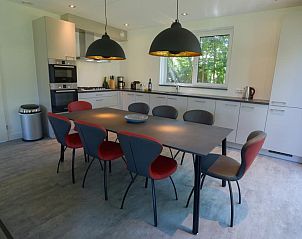 Dining room and kitchen in 06 - Razende Bol - allotment vacation home in De Koog, Texel with modern furnishings.
