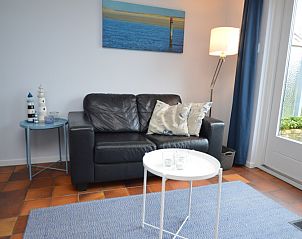 Knusse zithoek in Orchismient 45 klein, vakantiehuis in De Koog, Texel met comfortabele bank en decoratie.