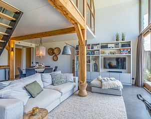 Gerumiges Wohnzimmer des Ferienhauses in De Koog mit gemtlicher Sitzecke und Bcherregalen auf Texel.