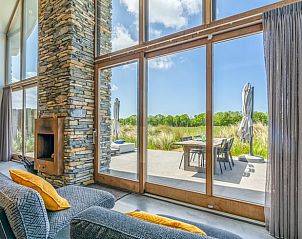 Groe Fenster im Ferienhaus in De Koog bieten einen schnen Blick auf die Terrasse und die Natur von Texel.