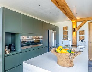 Moderne Kche im Ferienhaus in De Koog mit glatter Oberflche und Insel auf Texel.