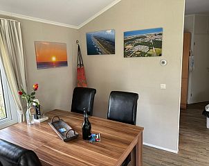 Gezellige eetruimte in Chaletpark Bregkoog, chalet 214 in De Koog, Texel, met kunst aan de muur en een uitnodigende sfeer.