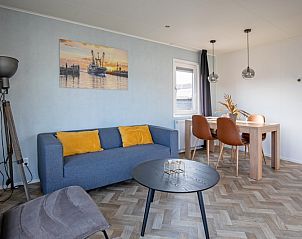 Sfeervolle zithoek in Chalet Bregkoog 162, Chaletpark Bregkoog, De Koog, Texel, met moderne kunst aan de muur.