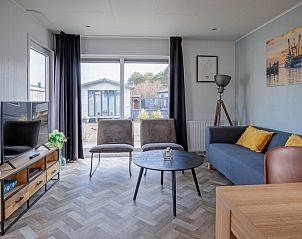 Ruime woonkamer van Chalet Bregkoog 162, Chaletpark Bregkoog, De Koog, Texel, met uitzicht op de tuin.