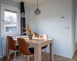 Eethoek in Chalet Bregkoog 162, Chaletpark Bregkoog, De Koog, Texel, met houten tafel en stijlvolle stoelen.