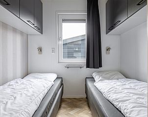 Tweede slaapkamer in Chalet Bregkoog 162, Chaletpark Bregkoog, De Koog, Texel, met twee eenpersoonsbedden en opbergruimte.