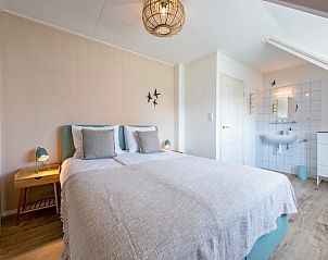 Gezellige slaapkamer in Vogelweelde, De Koog, Texel met tweepersoonsbed en zachte verlichting.