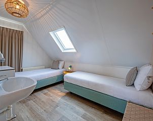 Tweepersoons slaapkamer in Vogelweelde, De Koog, Texel met moderne inrichting en dakraam.