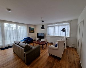 Lichte en ruime woonkamer in Bungalow Epelaan 13, De Koog, Texel. Vakantiehuis met stijlvolle inrichting en grote ramen.