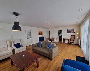 Open leefruimte in Bungalow Epelaan 13, De Koog, Texel. Vakantiehuis met moderne inrichting en houten vloeren.