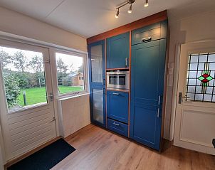 Keuken met tuinzicht in Bungalow Epelaan 13, De Koog, Texel. Vakantiehuis met toegang tot de tuin en veel natuurlijk licht.
