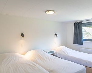 Ruime slaapkamer met drie bedden in Bungalow 1, De Koog, Texel, ideaal voor families.