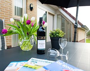 Genieen Sie ein Glas Wein auf der Terrasse von Villa 9, Ferienhaus in De Koog Texel, umgeben von Natur.