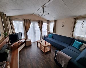 Spacious living room with large windows in Chaletpark Bregkoog, De Koog, Texel.