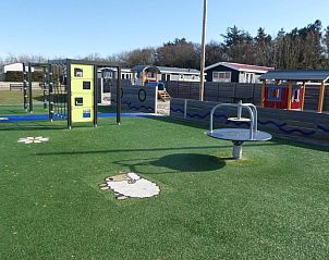 Kindvriendelijke speelruimte bij Chalet Bregkoog 27, De Koog, met diverse speeltoestellen en grasvelden.