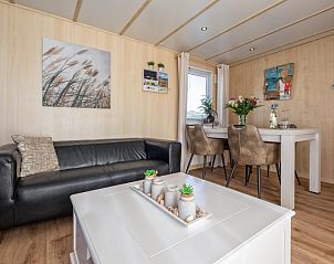 Chalet Bregkoog 27, De Koog Texel, biedt een stijlvolle zithoek met comfortabele banken en decoratieve accenten.