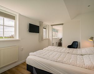 Hoofdslaapkamer in De Zandhaas, vakantiehuis op Texel, met comfortabel bed en serene omgeving voor een goede nachtrust.