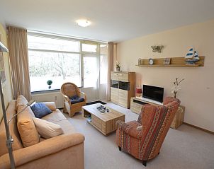 Gemtliches Wohnzimmer des Appartements Kerckeland 68 in De Koog, Texel mit bequemer Sitzecke und Blick auf die Natur.