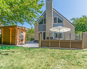 Vakantiehuis Kamperfoelie 43 met sauna in De Koog, Texel, omgeven door een groene tuin en zonnig terras.