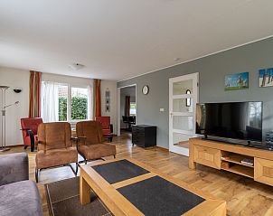 Lichte woonkamer van Vakantiehuis Kamperfoelie 43 met sauna, De Koog, Texel, met grote ramen en knusse zithoek.