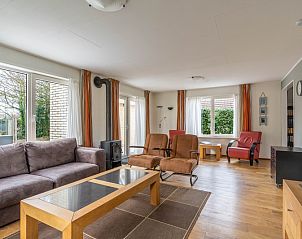 Gezellige zithoek in Vakantiehuis Kamperfoelie 43 met sauna in De Koog, Texel, met comfortabele stoelen en houtkachel.