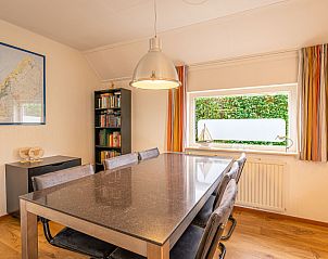 Eetkamer van Vakantiehuis Kamperfoelie 43 met sauna, De Koog, Texel, met grote tafel en uitzicht op de tuin.