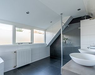 Luxe badkamer van Vakantiehuis Kamperfoelie 43 met sauna, De Koog, Texel, met ruime douche en dubbele wastafel.