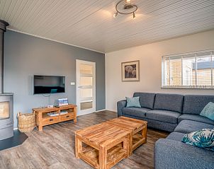 Knusse woonkamer met houtkachel in vakantiehuis Orchismient 2, De Koog, Texel, ideale plek voor ontspanning.