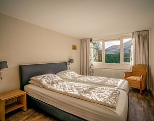 Tweede slaapkamer van vakantiehuis Orchismient 2 in De Koog, Texel, met ruime opzet en grote ramen.