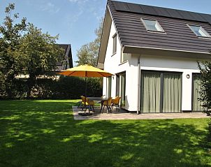 IJsvogel 10 in De Koog Texel met zonnig terras en gele parasol in de tuin.