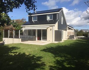 Ruime achtertuin van Huize 100-1, vakantiehuis in De Koog, Texel, omgeven door groen en rust.