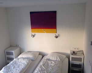 Slaapkamer met twee bedden in Huize 100-1, vakantiehuis in De Koog, Texel, voor een ontspannen nachtrust.