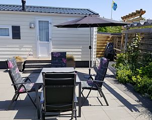 Zonnig terras met parasol en zitplaatsen bij Chalet Bregkoog 138 'Sinne', De Koog, Texel.