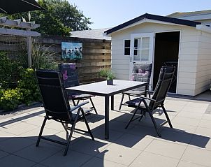 Buitenterras met zitgelegenheid bij Chalet Bregkoog 138 'Sinne', De Koog, Texel voor ontspannen momenten.