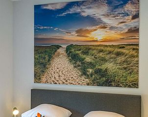 Slaapkamer van Tapuit 10a vakantiehuis in De Koog, Texel met kunst aan de muur.