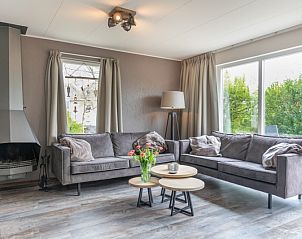 Gezellige woonkamer in Stappeland - De Groene Boei, vakantiehuis op Texel, met comfortabele banken en open haard.