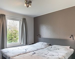 Slaapkamer in Stappeland - De Groene Boei, vakantiehuis op Texel, met twee eenpersoonsbedden en rustgevende sfeer.