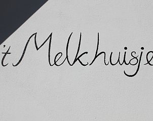 Buitenkant van vakantiehuis Melkhuisje in De Koog, Texel, met handgeschreven naam op de muur, gelegen op de Waddeneilanden.