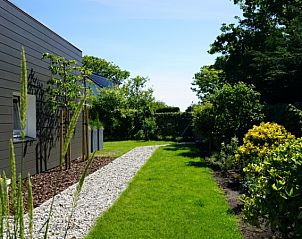 Groene tuin en wandelpad bij Bungalowpark 't Hoogelandt - Texelboogaloo in De Koog, Texel, ideale vakantiebestemming.
