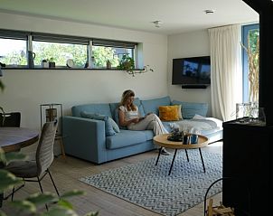 Knusse woonkamer in vakantiehuis Bungalowpark 't Hoogelandt - Texelboogaloo, De Koog, Texel, met comfortabele zithoek.